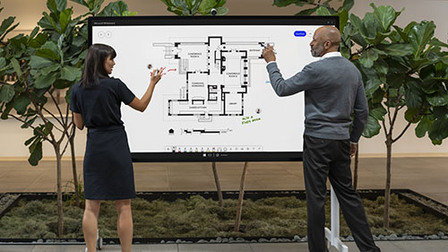Two people working on Surface Hub 2S