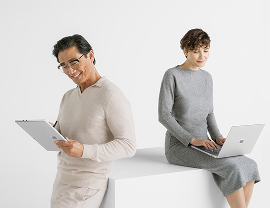 Two persons watching Surface device