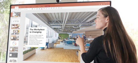 Person pointing at Surface Hub screen with an image of a room on it