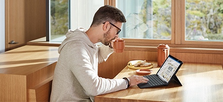 Person working on laptop at a kitchen table