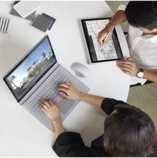 Overhead view of two people working on Surface devices