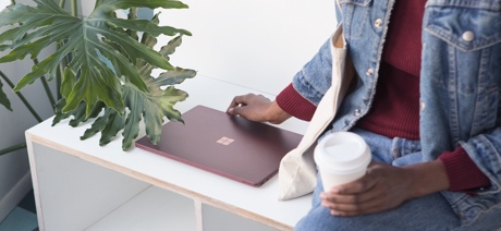 Person sitting on a bench with a laptop next to them