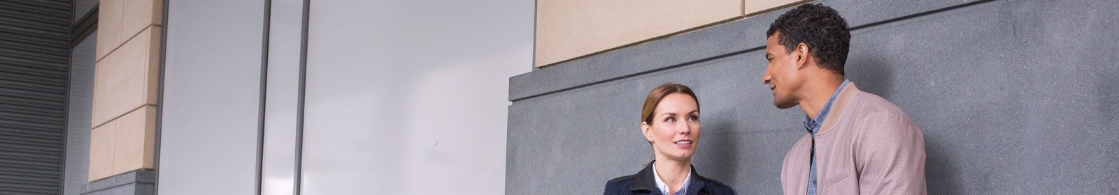 Two people talk in a hallway