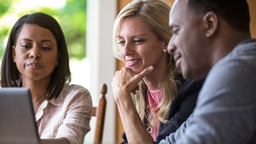 A group gathers around a laptop