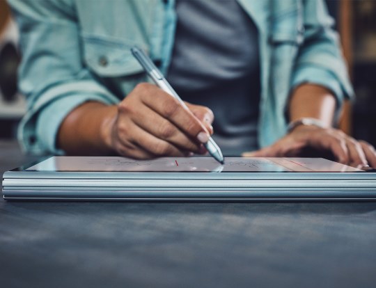 A person writes on a tablet