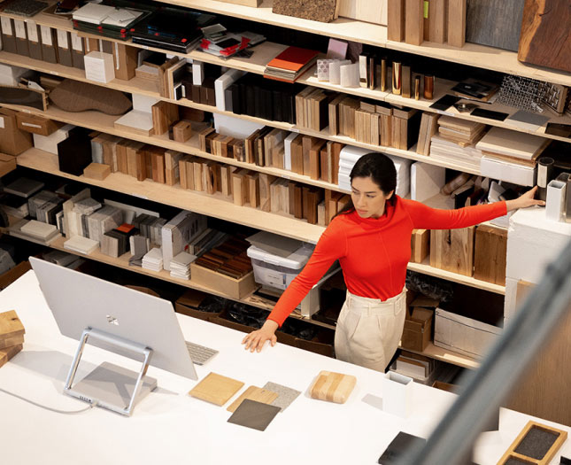 A woman standing in a workshop and looking at a large monitor