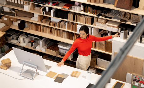 A woman standing in a workshop and looking at a large monitor