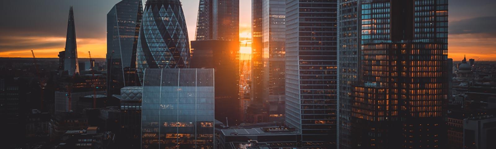 A panoramic view of London's skyline with a sunset background