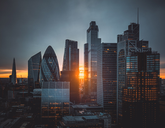 A panoramic view of London's skyline with a sunset background