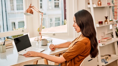女性がパソコンを見ながら左手で操作をしている写真です